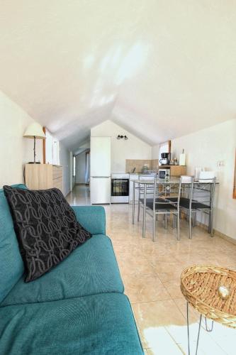 un salon avec un canapé bleu et une cuisine dans l'établissement La Maisonnette des Pins - Roquefort les Pins, à Roquefort-les-Pins