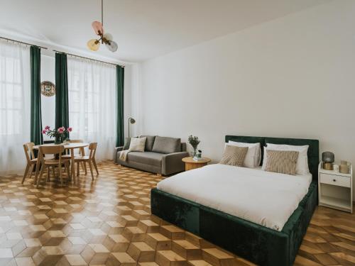 a bedroom with a bed and a couch and a table at S18 Apartments in Kraków