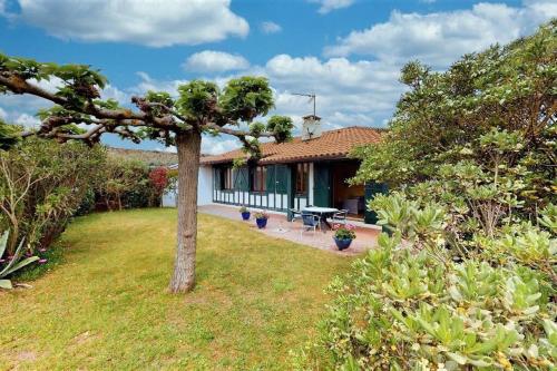une maison avec un arbre dans la cour dans l'établissement Hossegor Plage, Maison landaise 6 personnes, à Soorts-Hossegor