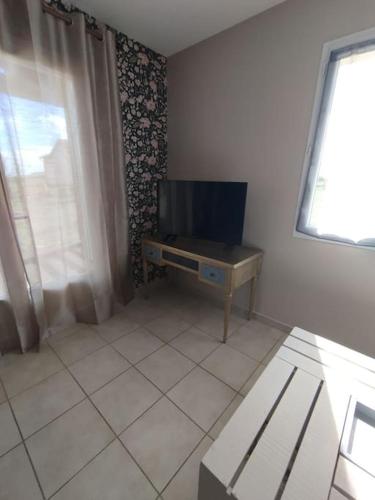 un salon avec une télévision sur une table dans l'établissement Maison 'La clé des champs', à Le Bouchet-Saint-Nicolas
