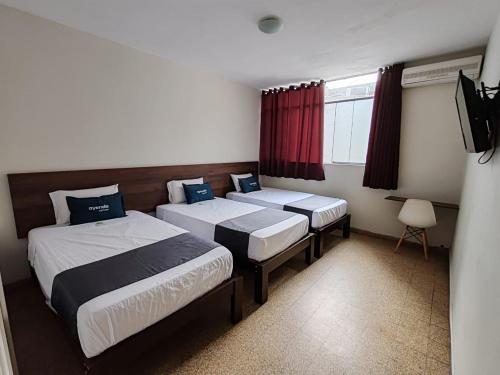 Habitación de hotel con 2 camas y TV en Nuevo Bamboo, en Piura
