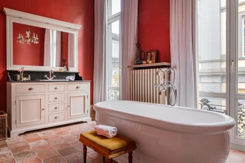 Łazienka z białą wanną i czerwonymi ścianami w obiekcie The Bank 1869 - Unique guestrooms in the historic center of Bruges w Brugii