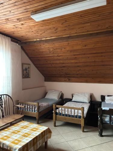 a room with two beds and a wooden ceiling at B&B Lukač in Kutina