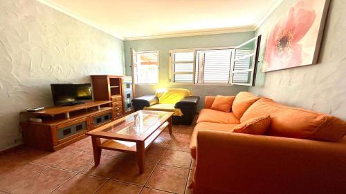 sala de estar con sofá y TV en Ayre Powered by SolymarCalma, en Costa Calma