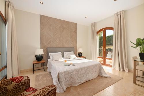 a bedroom with a large bed and two chairs at Casa Ceylan Luxury 8 Bed Villa with Sea, Golf & Mountain Views in Sotogrande