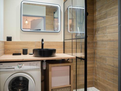 une salle de bain avec un lavabo et une machine à laver dans l'établissement T2 tout confort proche centre Hyères & plages, à Hyères