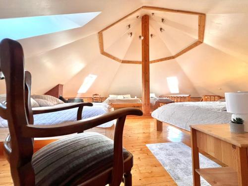 Zimmer mit 2 Betten und einem Stuhl in der Unterkunft Ziedu pirts in Auciems