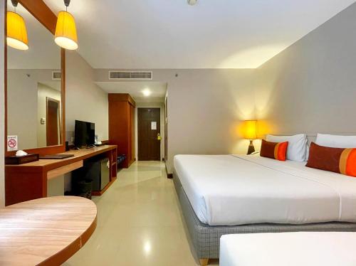 a hotel room with two beds and a television at Sabai Sabana in Pattaya Central
