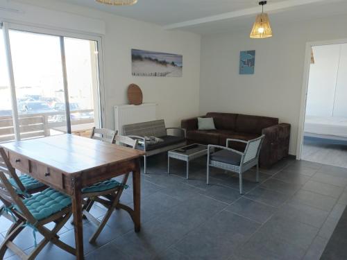 un salon avec un canapé, une table et des chaises dans l'établissement Au pied de la dune, à Biscarrosse
