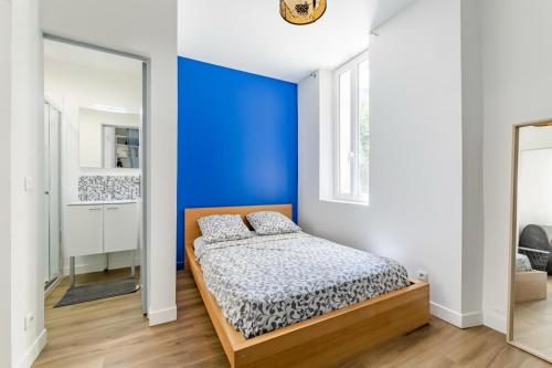 - une chambre avec un mur bleu et un lit dans l'établissement Studio proche Plage du Mourillon Confort et Charme, à Toulon