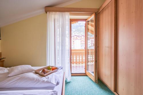 a bedroom with a bed with a bowl of fruit on it at Berg Hotel Latemar Spitze in Vigo di Fassa