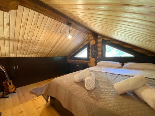 ein Schlafzimmer mit einem großen Bett im Dachgeschoss in der Unterkunft Wood house Halkidiki in Nea Fokea