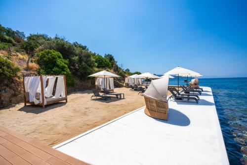 a group of chairs and umbrellas on a beach at Labranda TMT Bodrum in Bodrum City