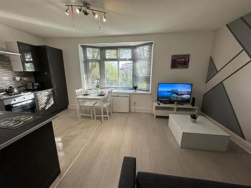 a living room with a table and a tv in it at Luton Town Centre Apartment in Luton
