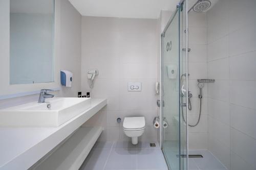a bathroom with a toilet and a sink and a shower at Labranda TMT Bodrum in Bodrum City