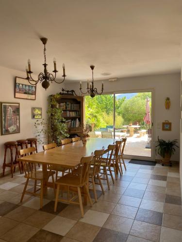 une salle à manger avec une table et des chaises en bois dans l'établissement Chambres d'hôtes l'Olivette des Albères, à Saint-André