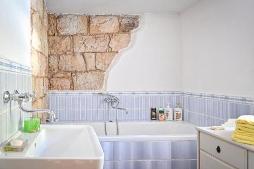 a bathroom with a white tub and blue tiles at Roubenka nad přehradou in Trutnov
