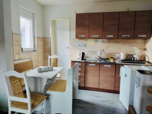 uma pequena cozinha com uma mesa branca e uma mesa em Apartman Mir em Visoko