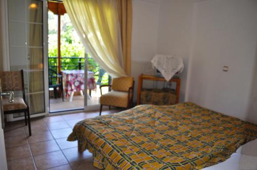 ein Schlafzimmer mit einem Bett und ein Balkon mit einem Tisch in der Unterkunft Holiday House Litsa 50 metres from Agios Gordios Beach in Agios Gordios