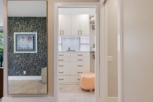 a kitchen with white cabinets and a mirror at *Condo - 490 E Via Ensenada Cir, 92264 in Palm Springs