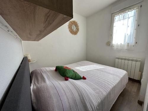 une chambre avec un animal en peluche vert sur un lit dans l'établissement Appartement 4 à 6 personnes accès direct plage Miramar, à La Londe-les-Maures