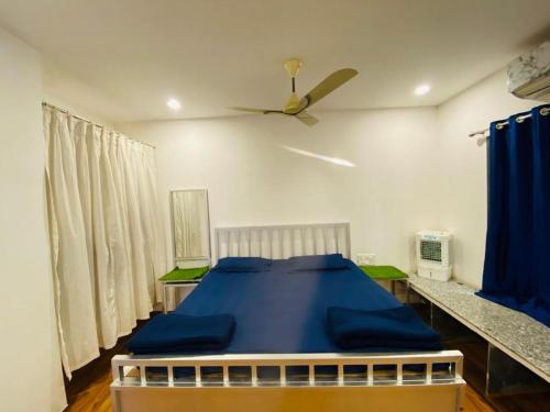 een slaapkamer met een blauw bed en een plafondventilator bij Palmquist Villa in Neral