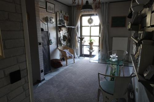 ein Wohnzimmer mit einem Fenster, einem Tisch und Stühlen in der Unterkunft La belle etage in Coesfeld