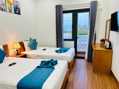 um quarto de hotel com duas camas e uma janela em Hotel Phạm Gia Phan Thiết em Phan Thiet