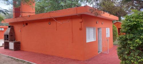 un edificio naranja con una ventana y una puerta en Cabañas TERMALES en Termas de Río Hondo