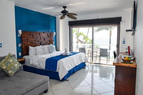 - une chambre dotée d'un lit avec un mur bleu dans l'établissement Mar Celeste, à Manzanillo