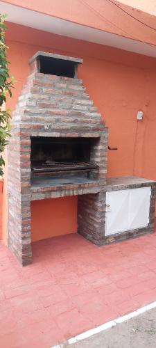 un horno de ladrillo al aire libre situado en un lateral de un edificio en Cabañas TERMALES en Termas de Río Hondo