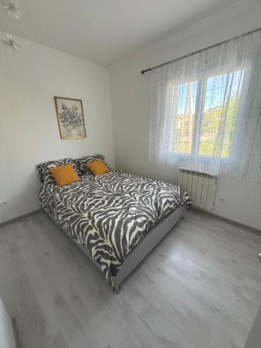 Cette chambre blanche dispose d'un lit à motifs zébrés et d'une fenêtre. dans l'établissement Sky housse, à Alès