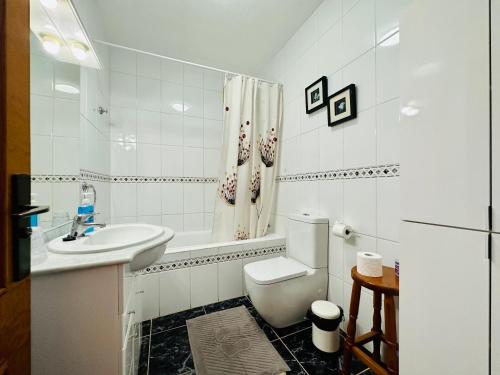 La salle de bains blanche est pourvue de toilettes et d'un lavabo. dans l'établissement Quiet Coral Mar, à Arona