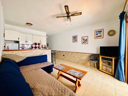 ein Wohnzimmer mit einem Sofa und einem Tisch in der Unterkunft Quiet Coral Mar in Arona
