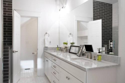 a white bathroom with a sink and a mirror at NEW Music Icon House in East Nashville in Nashville