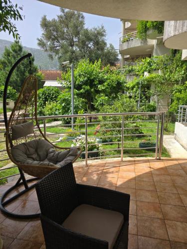 a porch with a chair and a swing at Roman Garden Apartment in Risan