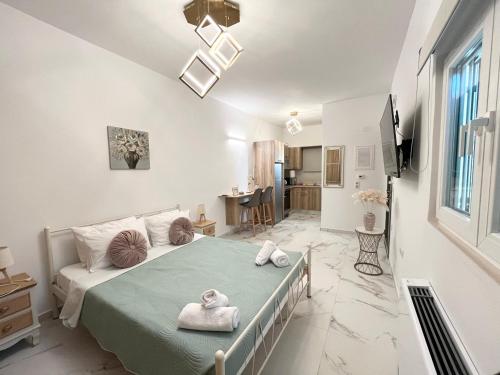 1 dormitorio con 1 cama con toallas en Corfu Airport Sweet Studio, en Ágios Rókkos