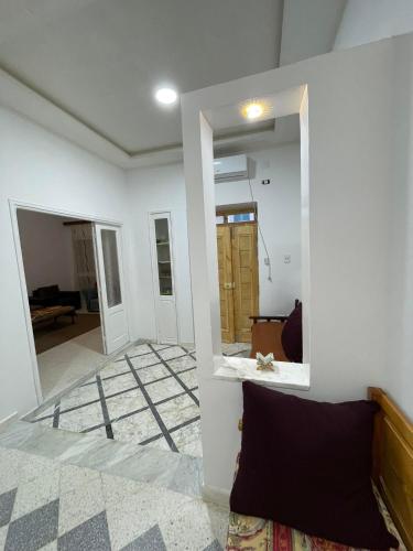 a living room with white walls and a mirror at Dar Zeneb in Borj el Handousse
