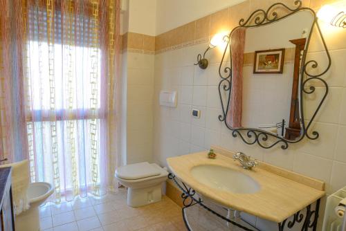 a bathroom with a sink and a toilet and a mirror at Casa Milena - VADOALMARE Immobiliare in Vado Ligure