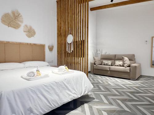 a bedroom with a bed and a couch at Encantador apartamento vigas de madera in Valencia
