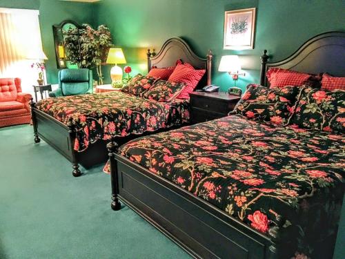 Elkhart LakeにあるVictorian Inn Elkhart Lakeの緑の壁のベッドルーム(ベッド2台付)