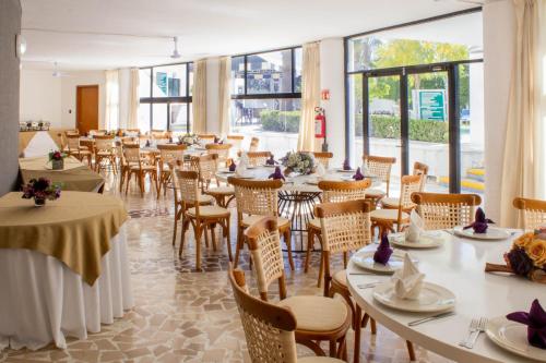 a dining room with tables and chairs and windows at Holiday Inn Queretaro Zona Diamante by IHG in Querétaro