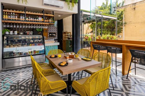 un restaurant avec une table en bois et des chaises jaunes dans l'établissement Torre Sofia magnific apartments & estudios with great amenities, à Cancún