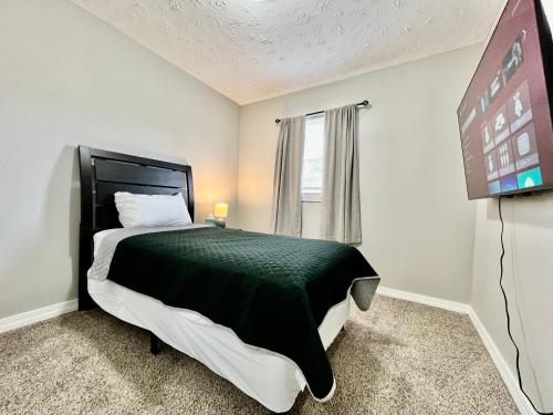 a bedroom with a black and white bed and a tv at A Great Place for Workers on Whitaker-Unit B in Hamilton