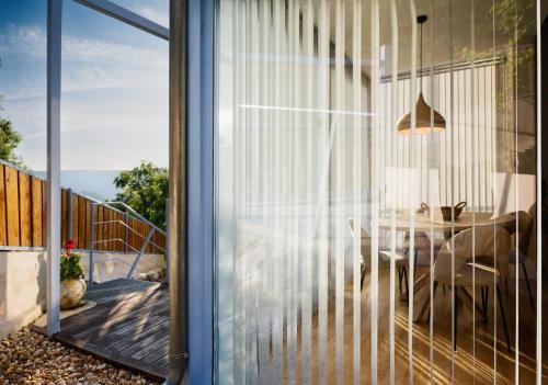 a glass door leading into a dining room with a table at O Souto da Aldea Ribeira Sacra Parada de Sil in Parada del Sil