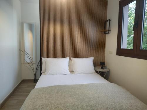 Un dormitorio con una cama con almohadas blancas y una ventana en 2Faros, en La Guancha
