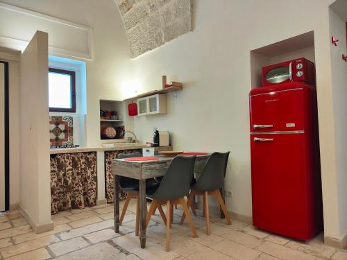 a kitchen with a table and a red refrigerator at Chez Liart 1 in Fasano