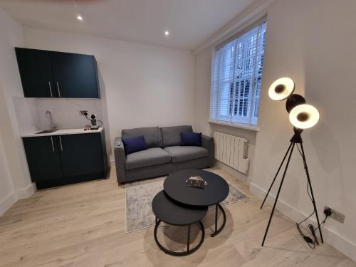 uma sala de estar com um sofá e uma mesa em Victoria Lodgings London em Londres