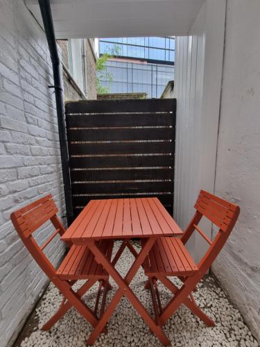 czerwony stół piknikowy i 2 krzesła na balkonie w obiekcie Victoria Lodgings London w Londynie