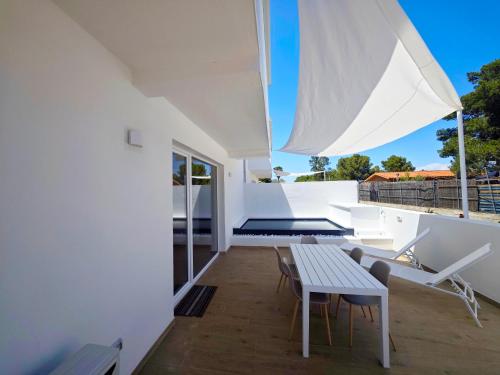 a room with a table and chairs on a balcony at Suite IKEBANA Porto Pino in Porto Pino
